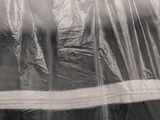 a black and white photo of a cat hiding in a plastic bag