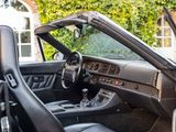 the interior of a black sports car parked in front of a house