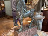 a statue of a man riding a horse on a marble table