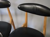 two black leather chairs with wooden legs and a black seat