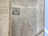 an old book opened to reveal a page of text on a white surface