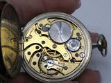 a close up of a person holding a pocket watch in their hand