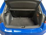 the back of a blue car with its trunk open showing the cargo compartment