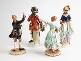 three figurines of people dressed in period clothing and hats