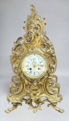 a gold clock that is sitting on a table