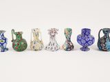 several vases are lined up in a row on a white surface