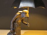 a statue of a man holding an umbrella on a table