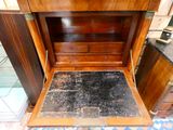 a wooden cabinet with a door open on a tile floor