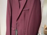 purple suit hanging on a hanger in front of a mirror
