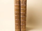deux vieux livres posés l'un sur l'autre sur une table