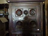 a wooden cabinet with many knobs on top of it