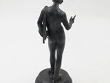 statue of a woman holding a gun on a white background