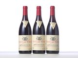three bottles of red wine sitting on top of a table