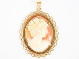 un gros plan sur le portrait d'une femme gravé sur un pendentif en or