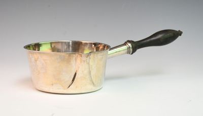 a silver sauce pot with a black handle on a white table