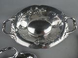 a silver plate with a spoon and a bowl on it