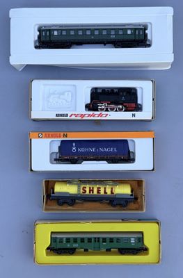 four different model trains are in boxes on a table