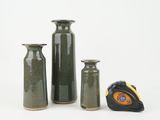 three vases and a measuring tape on a white surface