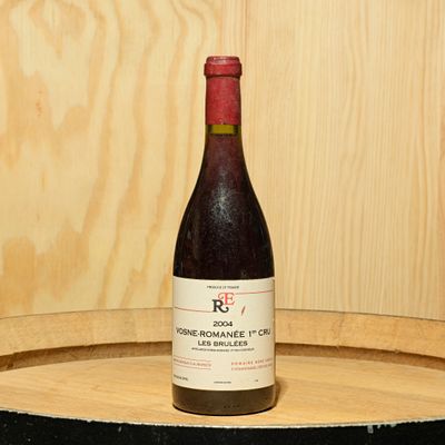 a bottle of wine sitting on top of a barrel
