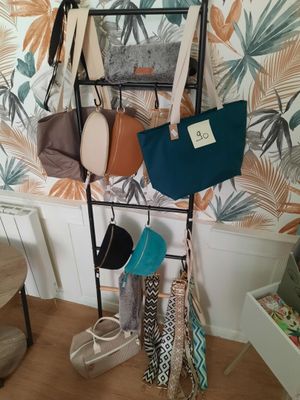 an image of a rack of purses and handbags hanging on a wall