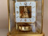 une horloge en or posée dans une vitrine, sur une table