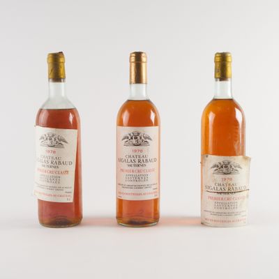 trois bouteilles de vin posées les unes à côté des autres sur une surface blanche