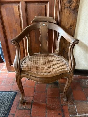 une chaise en bois posée sur un sol en briques