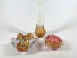 trois vases en verre posés l'un à côté de l'autre sur une table