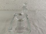 a clear glass candle holder with a bird on top of it