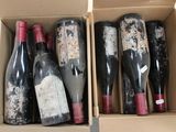 several bottles of wine are in a cardboard box on a table