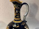 a blue and gold vase sitting on a white table