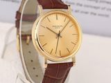 a gold watch with a brown leather band