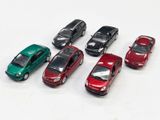 plusieurs petites voitures sont alignées sur une surface blanche