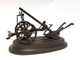 bronze model of a cannon and a wheel on a stand