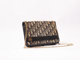a black and gold handbag with a chain on a white background