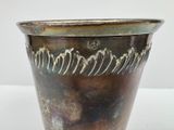 a metal vase that has a design on it