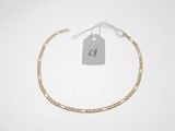 un bracelet en chaîne d'or auquel est attachée une plaque