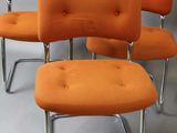 four orange upholstered chairs with chrome legs on a white background