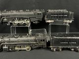 trois trains miniatures assis l'un à côté de l'autre sur une table