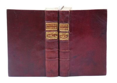deux livres sont posés l'un sur l'autre sur une surface blanche