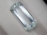 un diamant taille émeraude posé sur un tissu blanc