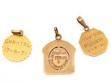 three gold pendants of different sizes and shapes on a white background