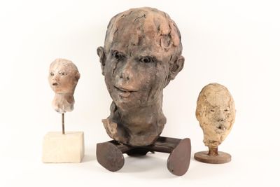 a statue of a man sitting next to three other sculptures