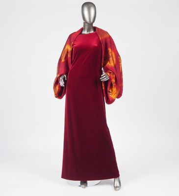 a woman ' s red dress with orange and yellow print on the sleeves