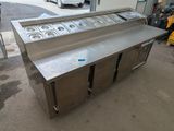 stainless steel counter top with four pans on it in front of a building