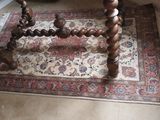 a wooden table with a red and white rug on the floor