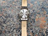 a close up of a watch on a table with a stone surface