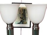 two lamps that are on a table with a picture on the wall behind them