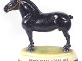 une statue représentant un cheval noir debout sur un socle