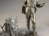 two silver figurines of a man and a woman on wooden bases